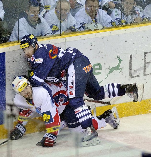 Lukáš Krejčí z Liberce (nahoře) tlačí k ledu pardubického Jana Koláře v semifinále extraligy.