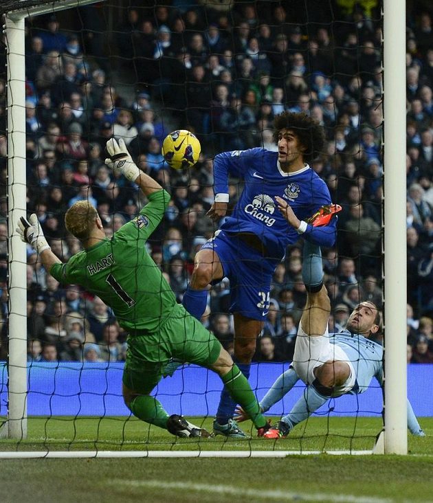 Marouane Fellaini (vpravo) z Evertonu střílí gól brankáři Manchesteru City Hartovi.
