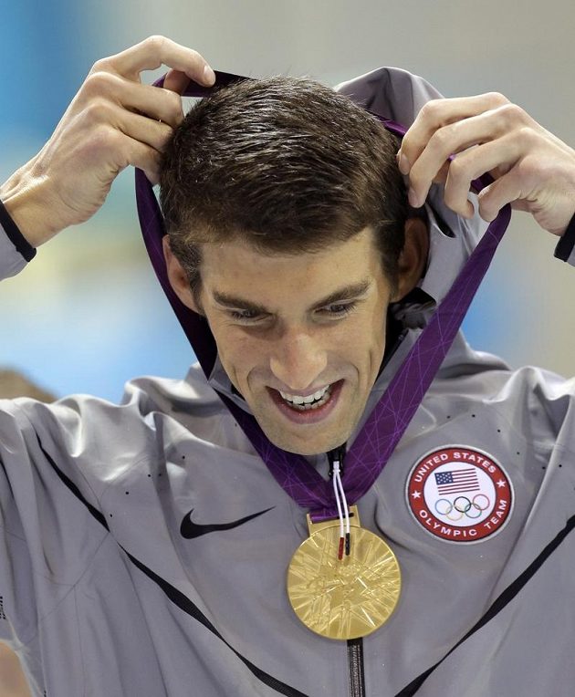 Sedmnácté olympijské zlato! Americký plavec Micheal Phelps si věší na krk zlatou medaili za triumf v závodě na 100 metrů motýlkem.