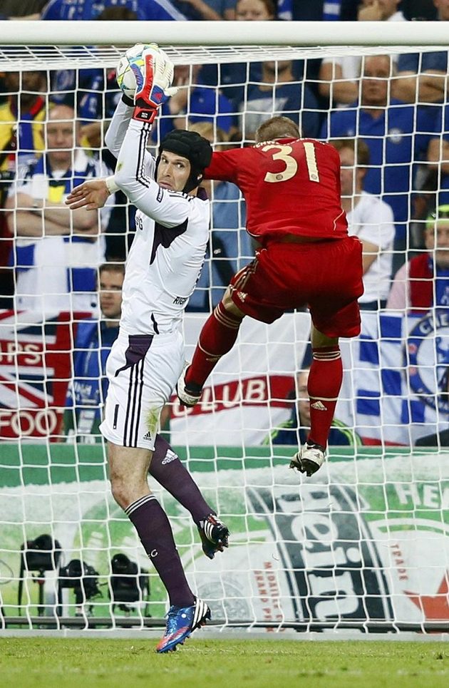 Brankář Chelsea Petr Čech chytá míč před Bastianem Schweinsteigerem z Bayernu Mnichov.