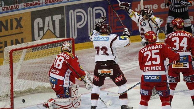 Hokejisté Sparty se radují, puk se zastavil v brance Slavie. Gólman Dominik Furch se jen bezmocně ohlíží.