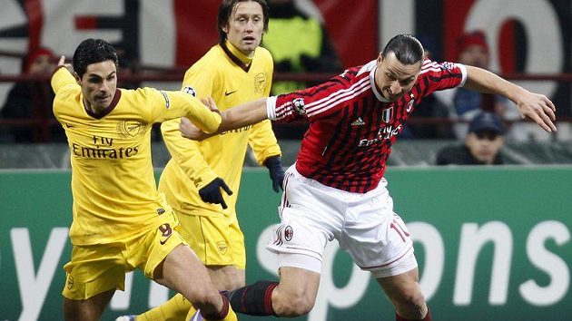 Tomáš Rosický (vzadu) z Arsenalu sleduje souboj Mikela Artety (vlevo) s útočníkem AC Milán Zlatanem Ibrahimovičem v osmifinále Ligy mistrů.