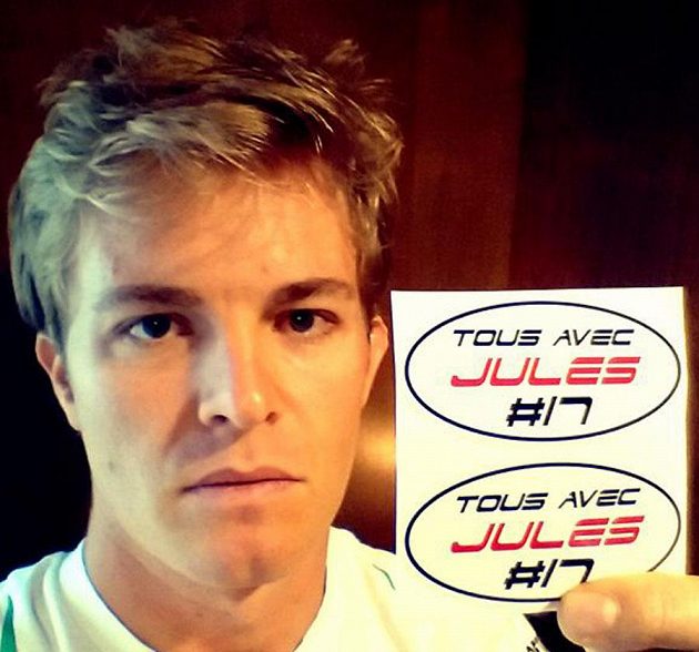 Nico Rosberg ukazuje nálepky se vzkazem Tous avec Jules (Všichni s Julesem), které budou mít jezdci vylepené v Soči na podporu svého těžce zraněného kolegy.