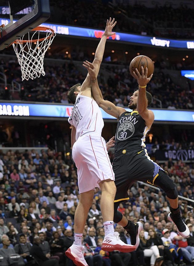 Hvězda Golden State Warriors Stephen Curry (30) se snaží prosadit ke koši přes bránícího Tomáše Satoranského z týmu Washington Wizards v utkání NBA.