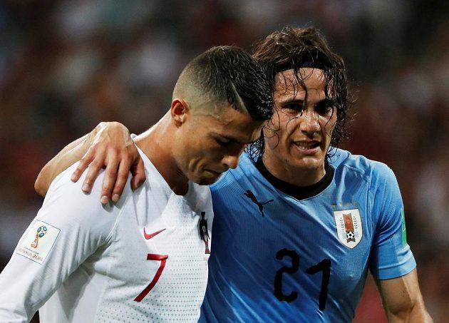 Opři se o mě, kamaráde... Portugalec Cristiano Ronaldo odvádí ze hřiště zraněného Uruguayce Edinsona Cavaniho.