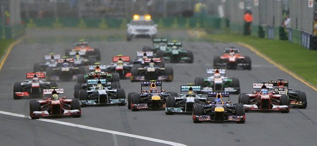Sebastian Vettel s vozem Red Bull (třetí zprava) vede jezdecké pole po startu Velké ceny Austrálie.