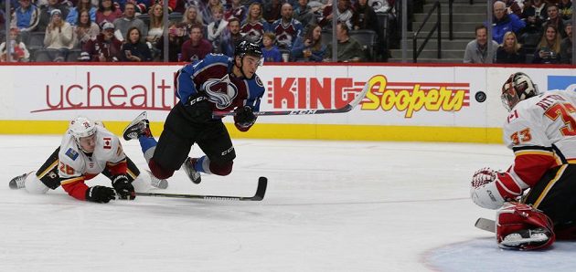 Ćeský brankář ve službách Calgary David Rittich (úplně vpravo) zasahuje proti pokusu centra Colorada Tysona Josta v utkání NHL.