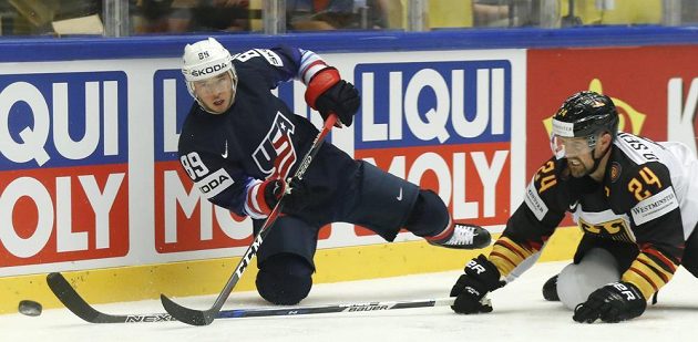 Německý zadák Dennis Seidenberg (vpravo) se snaží zastavit Cama Atkinsona z USA.
