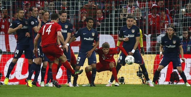 Xabi Alonso (14) dává vedoucí gól Bayernu - i s přispěním teče Josého Giméneze z Atlétika Madrid (druhý zprava).