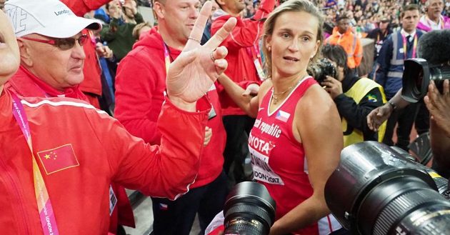 Barbora Špotáková poté, co se prodrala ke svému kouči Rudolfu Černému (v bílé kšiltovce).