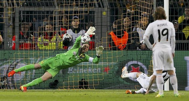 Brankář Dortmundu Roman Weidenfeller chytá penaltu Angelu di Maríovi z Realu v odvetě čtvrtfinále Ligy mistrů.