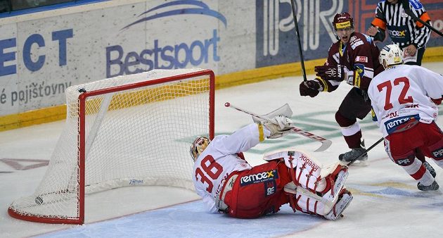 Sparťanský útočník Jan Buchtele (druhý zprava) střílí gól proti Slavii. Vpravo přihlíží obránce červenobílých Pavel Kolařík, na ledě leží brankář Dominik Furch.