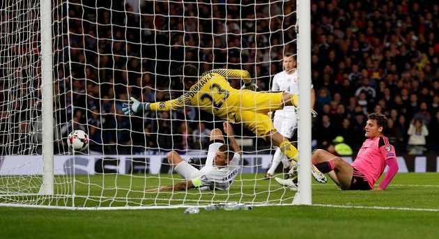 Vlastní gól, 1:0! Skot Chris Martin (v růžovém) sleduje, jak Martin Škrtel v tísni překonává Martina Dúbravku.