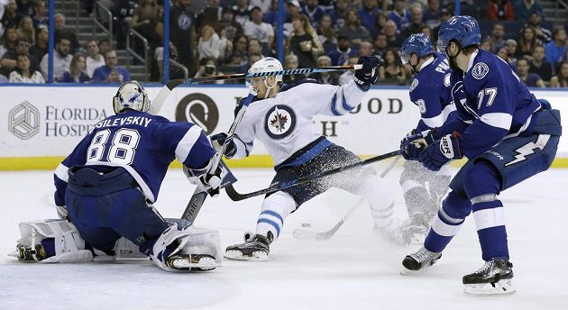 Joel Armia (40) z Winnipegu mezi bránícími hráči Tampy Ondřejem Palátem (18), Victorem Hedmanem (77) a gólmanem Andrejem Vasilevským (88).