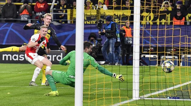 Rozhodující okamžik: Julian Brandt (druhý zleva) z Dortmundu překonává ve druhém poločasu z úhlu slávistického brankáře Ondřeje Koláře. Petr Ševčík přišel pozdě.