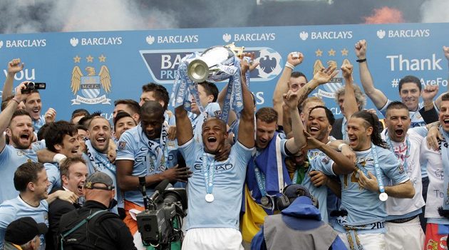 Kapitán Manchesteru City Vincent Kompany drží nad hlavou trofej pro vítěze Premier League.