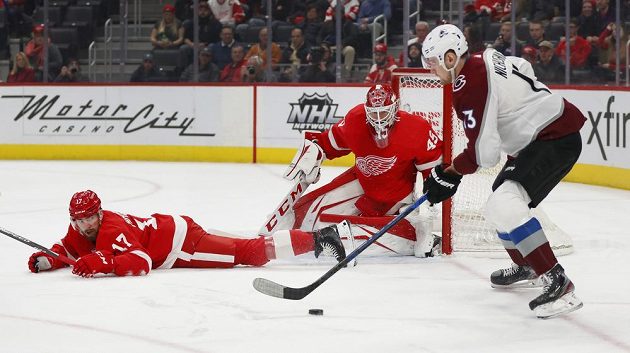Český obránce Detroitu Red Wings Filip Hronek (17) sleduje z ledové plochy spolu s brankářem Jonathanem Bernierem (45) útočnou akci útočníka Colorada Valerije Nichuškina v utkání NHL.