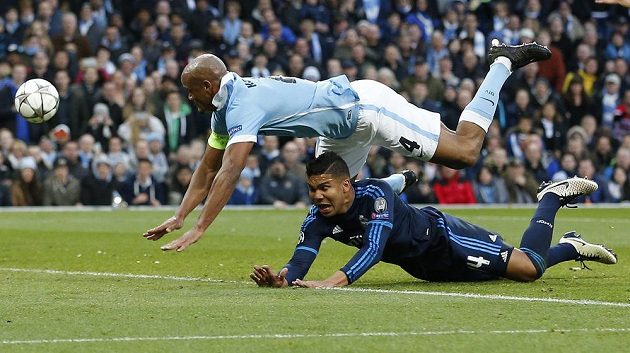 Zadák Manchesteru City Vincent Kompany (nahoře) fauluje Casemira z Realu Madrid.