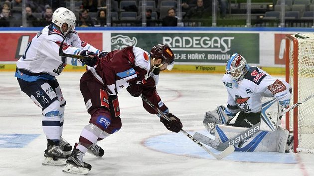 Chomutovský brankář Štěpán Lukáš likviduje šanci útočníka Dominika Uhra ze Sparty. Vlevo je obránce Pirátů Brett Flemming