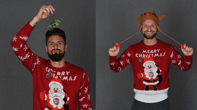 Giroud a Mustafi ve vánočních svetrech se Santa Clausem a logem Arsenalu.