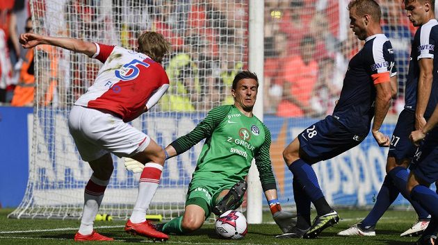 Marně dobývali slávisté obranný val Slovácka. Na snímku brankář Milan Heča vyráží střelu Pera Egila Flo ze Slavie.