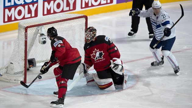 Zleva Jason Demers z Kanady se pokouší srazit puk, který podruhé míří do kanadské branky. Přihlížejí brankář kanadské reprezentace Chad Johnson a Antoine Roussel z Francie.