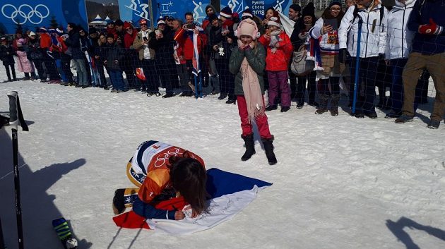 Eva Samková podepisuje českou vlajku, kterou jí po olympijském bronzu půjčila fanynka Gábina.