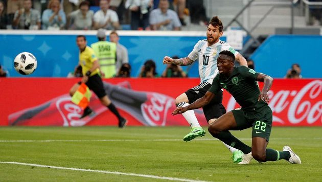 Míč míří do sítě, Argentina jde do vedení zásluhou Lionela Messiho (10). Marná je snaha Nigerijce Kennetha Omerua.