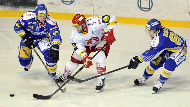 Třinecký útočník Martin Růžička (uprostřed) mezi zlínskými hráči Filipem Čechem (vlevo) a Petrem Holíkem.