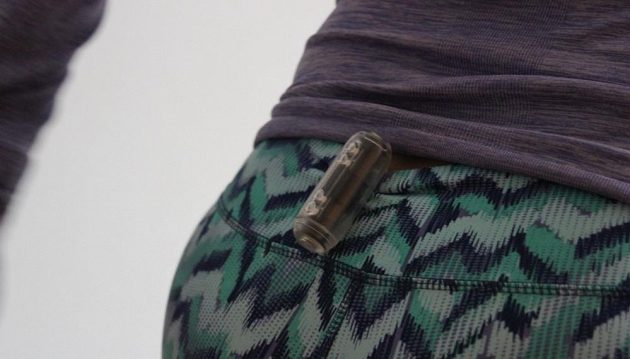Běžecká bezbateriová blikačka Kalenji Motion Light - uchytit ji můžete za přiložený pásek nebo za jakýkoli okraj oděvu (zde vzadu na kalhotách).