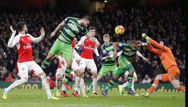 Ashley Williams (druhý zprava) ze Swansea překonává Petra Čecha v bráně Arsenalu.