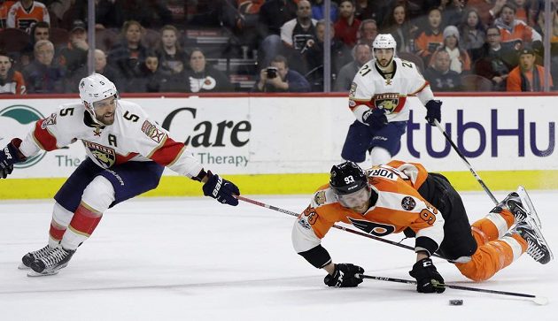 Bojovník Jakub Voráček z Philadelphie v pádu během prodloužení zápasu NHL s Floridou Panthers. Vlevo Aaron Ekblad z Floridy. Díky nájezdu Voráčka vyhráli Letci 2:1.
