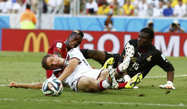 Thomas Müller z Německa (vpředu) bojuje o míč s ghanskou defenzívou v čele s gólmanem Daudou.