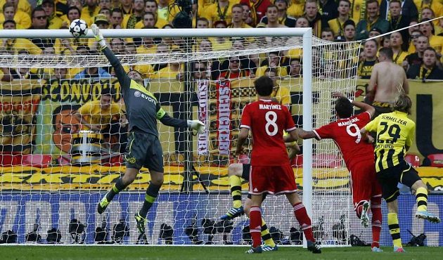 Brankář Dortmundu Roman Weidenfeller vytahuje nad břevno hlavičku Maria Mandžukiče.