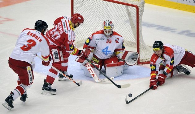 Třinecký útočník Jakub Klepiš (druhý zleva) se snaží překonat olomouckého brankáře Jiřího Trvaje. Vlevo je obránce Kohoutů David Škůrek. Vpravo pak útočník Marek Laš.