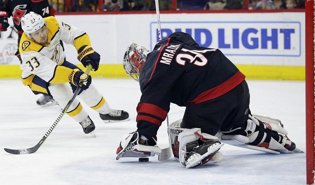 Švédský hokejista Viktor Arvidsson (33) z týmu Nashville Predators pálí na Petra Mrázka v brance Caroliny Hurricanes.