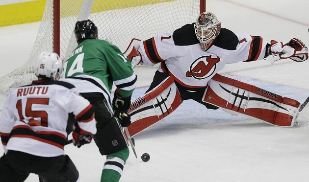 Kanadský útočník Jamie Benn (14) z Dallasu se snaží překonat brankáře New Jersey Keitha Kinklaida (1) v zápase NHL.