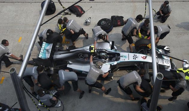 Mechanici Mercedesu mění gumy na voze Nika Rosberga při měřeném tréninku v Sepangu.