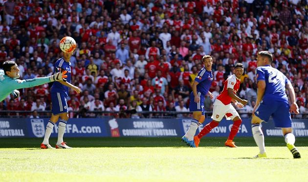 Alex Oxlade-Chamberlain z Arsenalu (druhý zprava) střílí gól brankáři Chelsea Thibautu Courtoisovi.