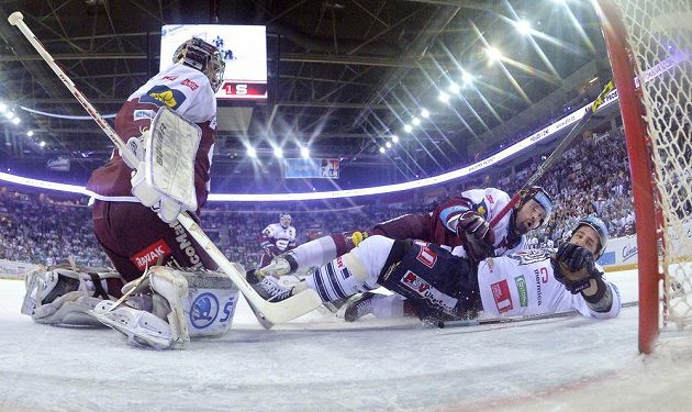 Liberecký hokejista Jaroslav Vlach (vpravo) a Jan Hlaváč s brankářem Tomášem Pöpperlem ze Sparty Praha.