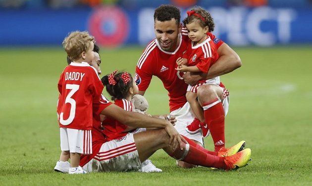 Fotbalisté Walesu Hal Robson-Kanu (vpravo) a Neil Taylor se svými ratolestmi na trávníku stadiónu v Lille po čtvrtfinálovém klání s Belgií.
