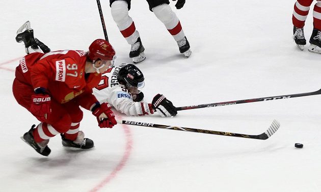 Ruský hokejista Nikita Gusev v souboji s Rakušanem Clemensem Unterwegerem v utkání mistrovství světa.