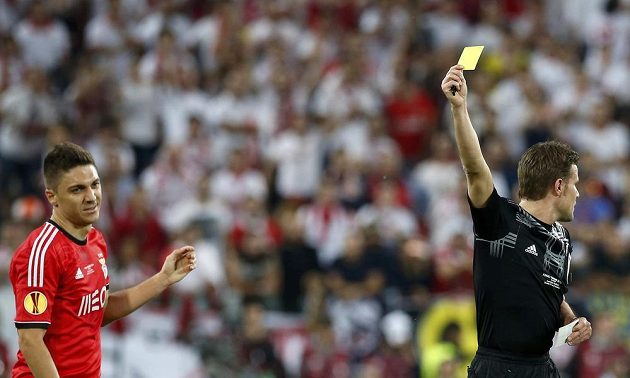 Guilherme Siqueira (vlevo) z Benfiky dostává žlutou kartu od sudího Felixe Brycha ve finále EL.