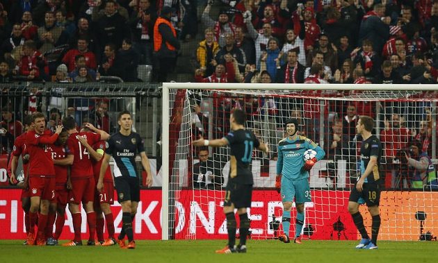 Rozladěný brankář Arsenalu Petr Čech (druhý zprava) vyčítavě sleduje své spoluhráče, zatímco fotbalisté Bayernu Mnichov oslavují trefu do jeho brány.