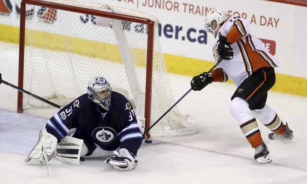 Brankář Ondřej Pavelec (31) z Winnipegu zasahuje proti střele Coreyho Perryho (10) z Anaheimu.