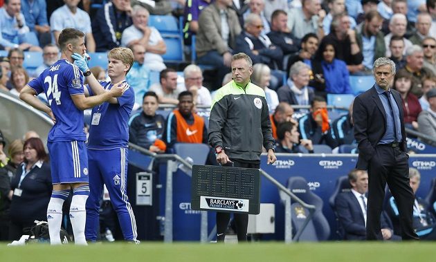 Lékař Chelsea Chris Hughes ošetřuje zraněného Garyho Cahilla pod přísným dozorem Josého Mourinha.