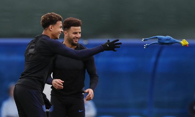 Anglický fotbalista Dele Alli (vlevo) se v rámci rozcvičky na tréninku připravoval s kohoutem.