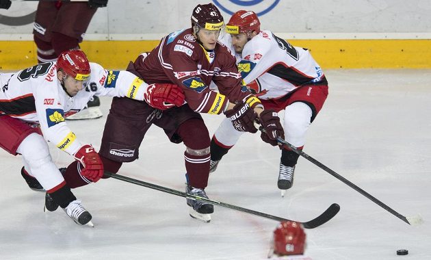 Jiří Vašíček (vlevo) a Rastislav Dej z Hradce Králové se snaží zastavit sparťanského útočníka Jana Buchteleho (uprostřed) v zápase 15. kola Tipsport extraligy.