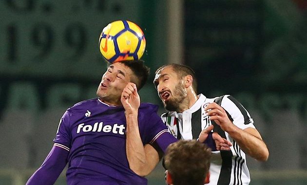 Giovanni Simeone v dresu Fiorentiny (vlevo) v ostrém hlavičkovém souboji s Giorgiem Chiellinim z Juventusu.