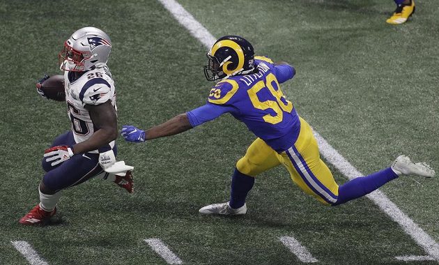 Sony Michel (26) z týmu New England Patriots utíká soupeři z Los Angeles Rams Corymu Littletonovi (58) během Super Bowlu.